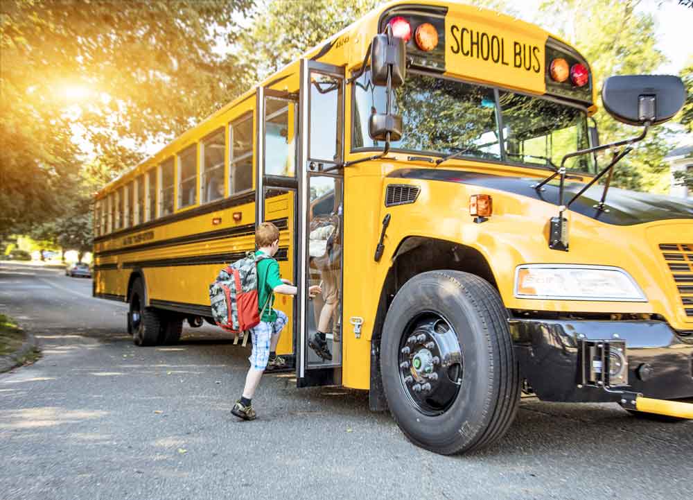 child getting on school bus