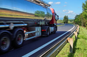 Truck Accident Lawyer Marietta, GA - Mirroring the landscape chrome tank truck moving on a highway, view from eye level